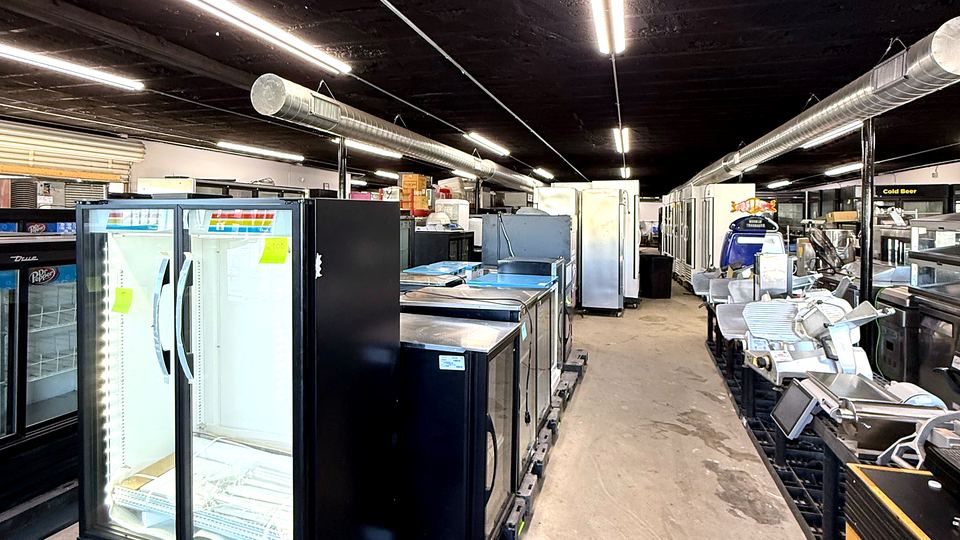 A lit row of 2-door Frozen Food glass freezers on the Efficient Equipment showroom floor in Amarillo.